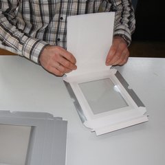 Bild aus dem Arbeitsbereich Montage. man sieht Hände einer Person, die eine Schachtel faltet.