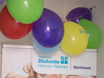 Luftballons oberhalb eines Roll-ups, auf dem das Oberhessen-Logo zu sehen ist.