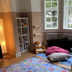 Innenansicht eines Raums im Friedberger Piccolino mit Stehlampe, Fenstern, bunten Kissen und Teppichen. Innenansicht eines Raums im Friedberger Piccolino mit Stehlampe, Fenstern, bunten Kissen und Teppichen.