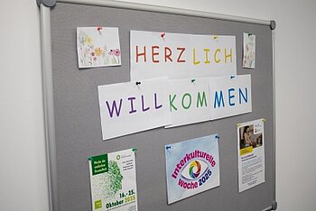 An einer Tafel hängen bunte Buchstaben: Herzlich willkommen.