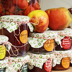 Bild von Marmeladengläsern und Äpfeln.