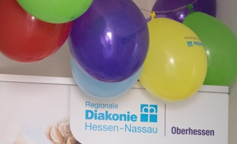 Luftballons über einem RDO-Roll-Up, auf dem das Oberhessen-Logo zu sehen ist.
