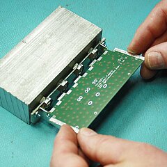 Bild von den Händen einer Person, die eine Platine hält.